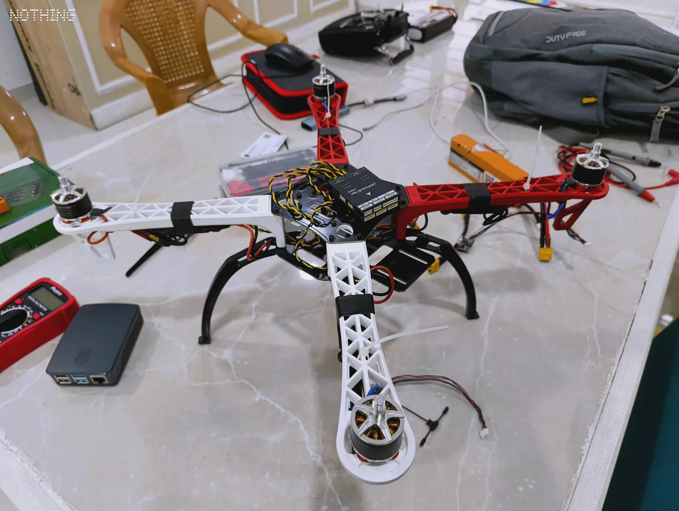 Assembled quadcopter drone with landing gear standing on a workbench
