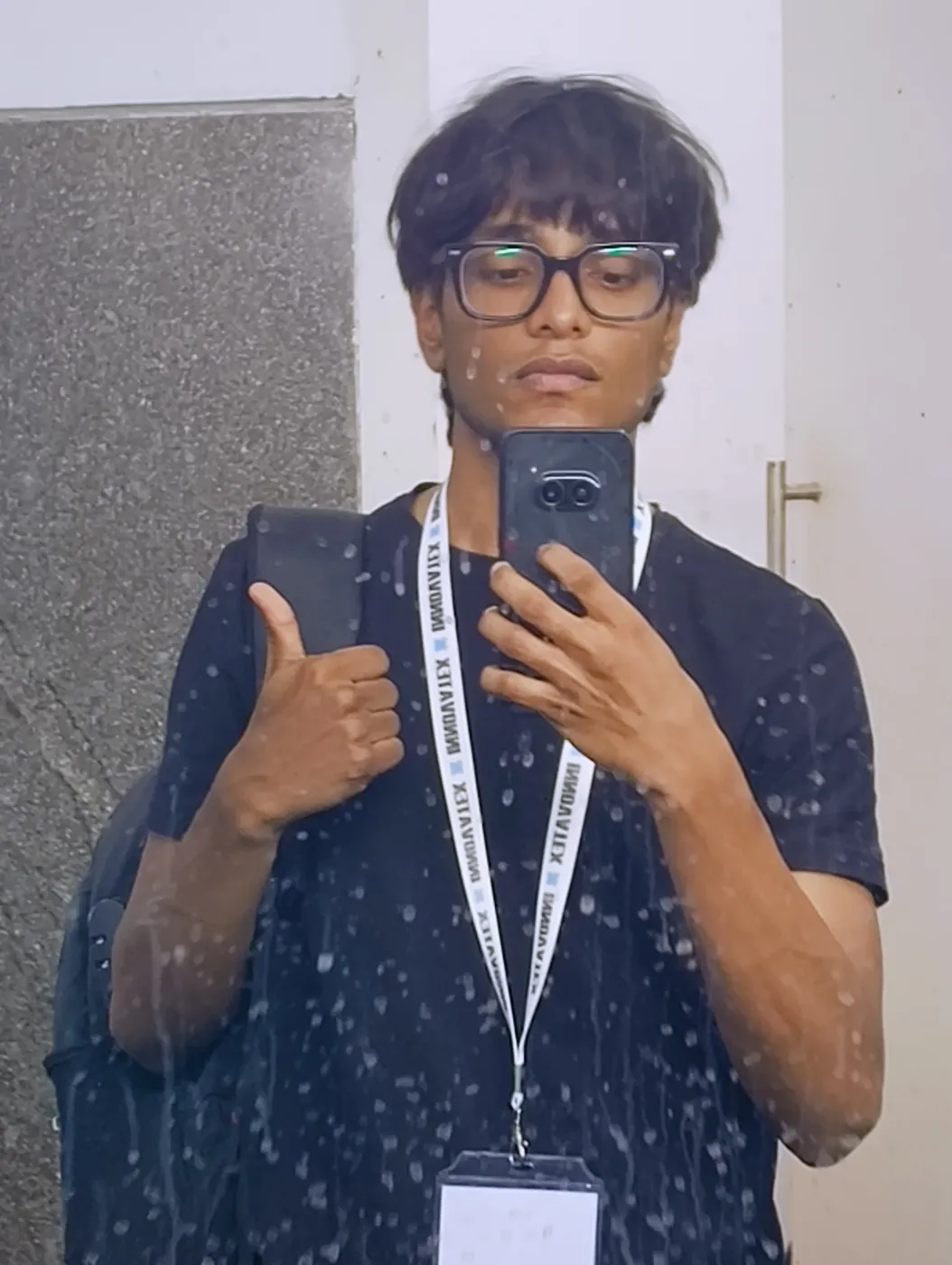 Mirror selfie of Sonu Kumar Suman wearing an event lanyard and giving a thumbs up