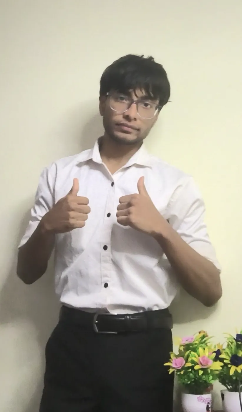 Sonu Kumar Suman in a white shirt and black tie giving two thumbs up